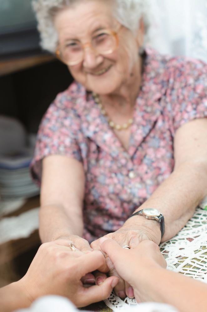 Young hand holding an elderly pair of hands